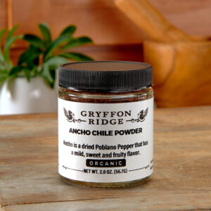 A jar of Ancho Chile Powder ~ Certified Organic on a white plate.