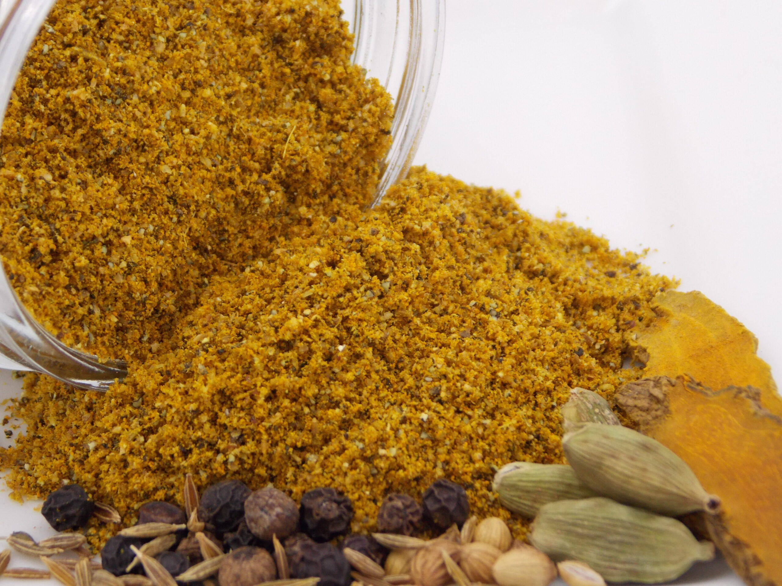 A jar full of Curry Powder ~ Certified Organic on a white surface.