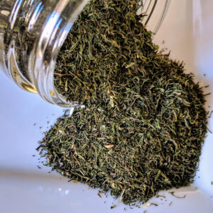 A jar filled with Dill Weed ~ Certified Organic on a white plate.