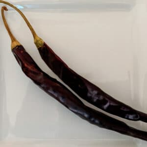 Two Puya Chiles on a white plate.