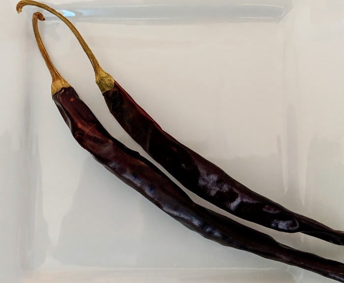 Two Puya Chiles on a white plate.