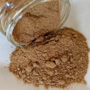 Ginger Root Powder ~ Certified Organic in a jar on a white plate.