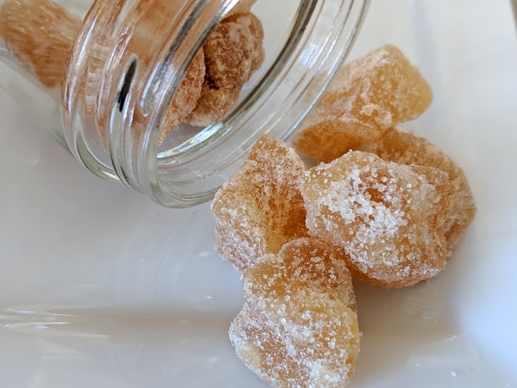 A jar of Ginger, Crystallized ~ Certified Organic on a white plate.