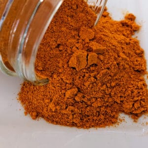 A jar of Turmeric Root Powder ~ Certified Organic on a white plate.