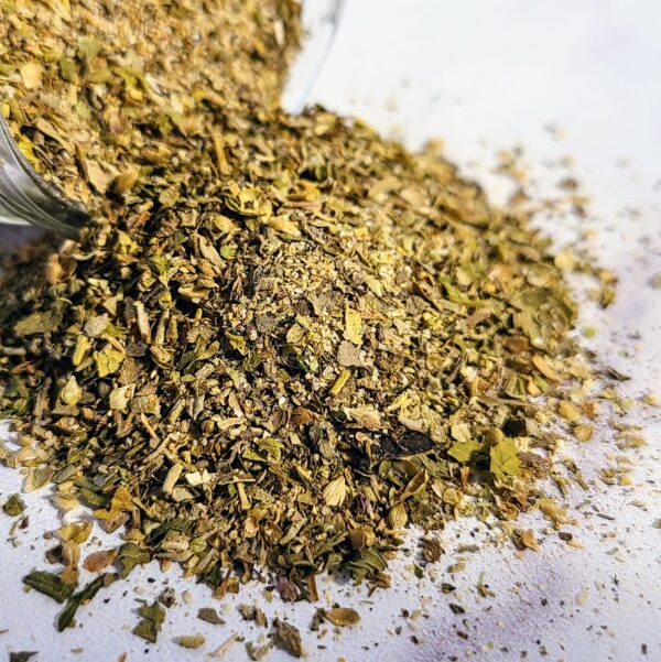 A pile of La Bella Vita ~ Certified Organic dried herbs on a white surface.