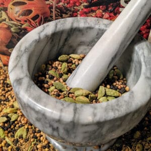 A mortar and pestle with spices in it.