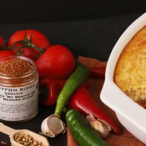 A dish of 24 Jar Spice Starter Kit cheese casserole with peppers and tomatoes on a table.